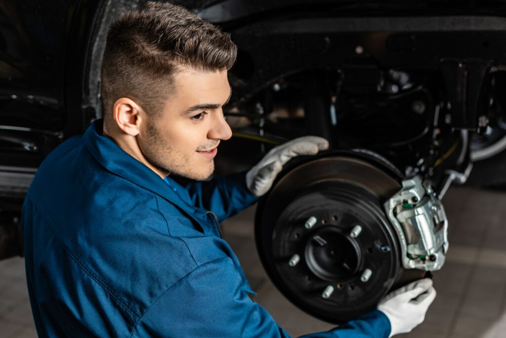 handsome mechanic adjusting assembled disc brakes with brake caliper